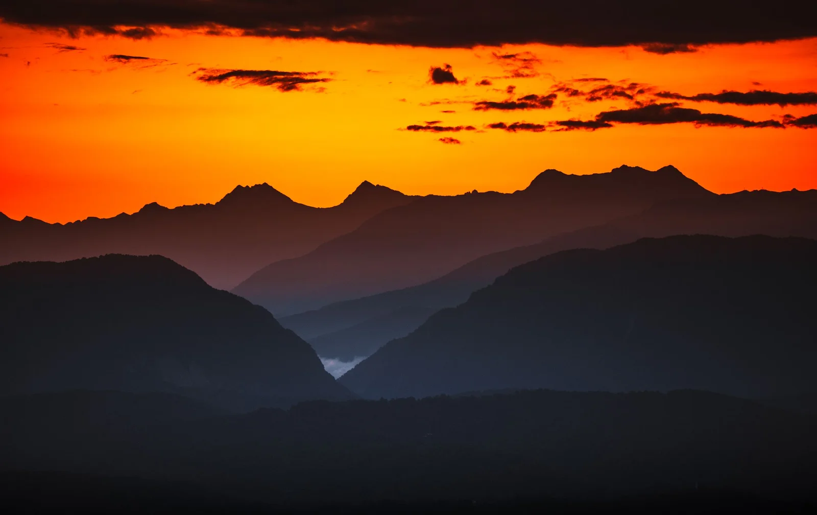 Silhuetas de montanhas ao pôr do sol